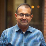 Debashish Chakravarty, VOANS Vice President of Real Estate Development, wearing glasses and a blue checkered button up shirt